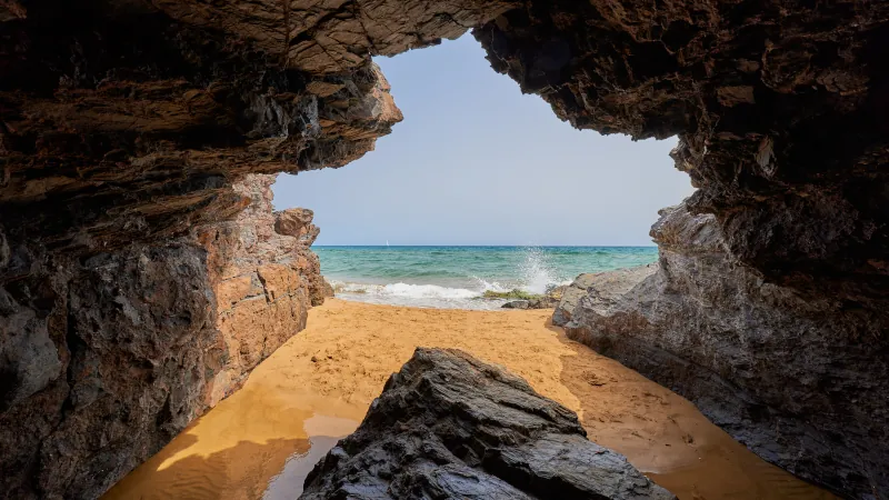 Cave by the sea and girl taking a bath. Calblanque Regional Park in Murcia