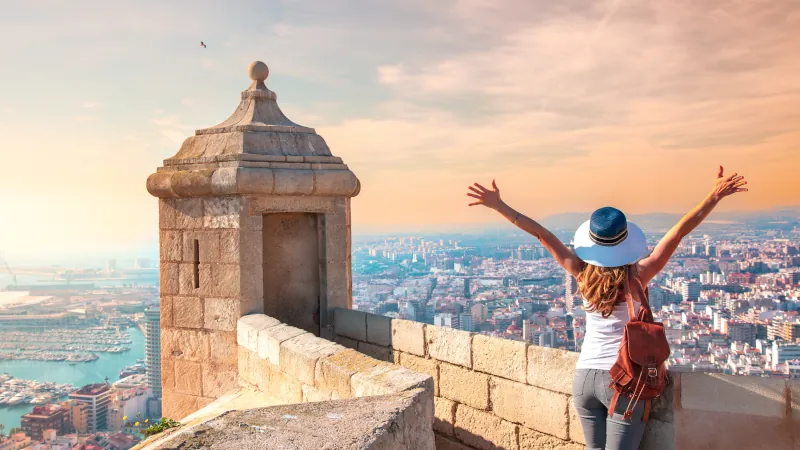 Alicante Santa Barbara castle in Costa Blanca, happy woman tourist looking at panoramic city landscape view