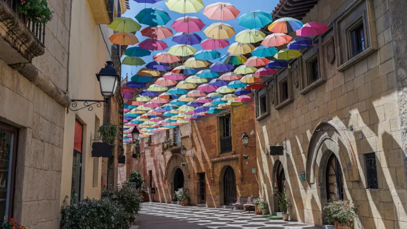 Umbrellas Suspended and Joined with Each other in a Street of Poble Espanyol to Form a Roof of Colorful Umbrellas, Barcelona, Spain