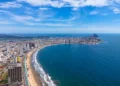 An aerial view of Mazatlán Beach on a sunny morning, showcasing the blue ocean's gentle waves meeting the sandy shores of this popular tourist destination