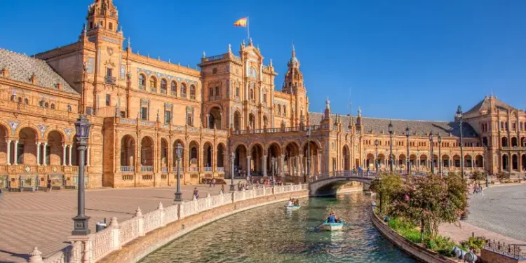 Plaza de España in Seville with canal and historic building under a clear blue sky