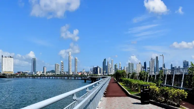 Waterfront promenade overlooking Panama City’s modern skyline under a bright blue sky.