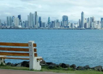 Panama City skyline viewed from waterfront park with bench in foreground