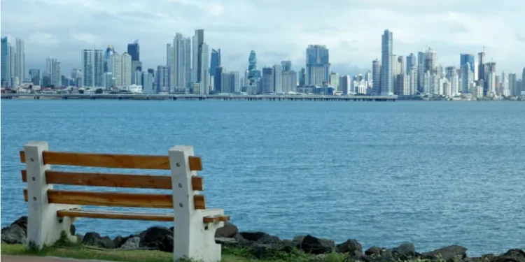 Panama City skyline viewed from waterfront park with bench in foreground