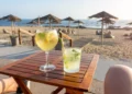 Woman enjoying a Porto tonic cocktail at a beach bar in Porto, Portugal