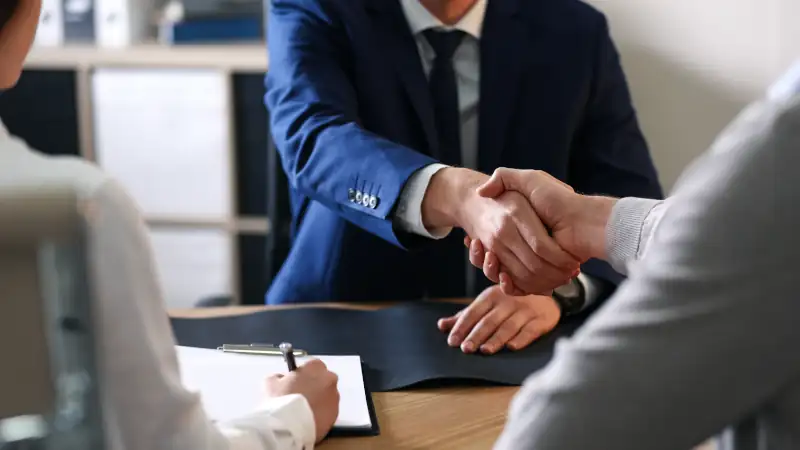 Male lawyer working with clients in office, closeup