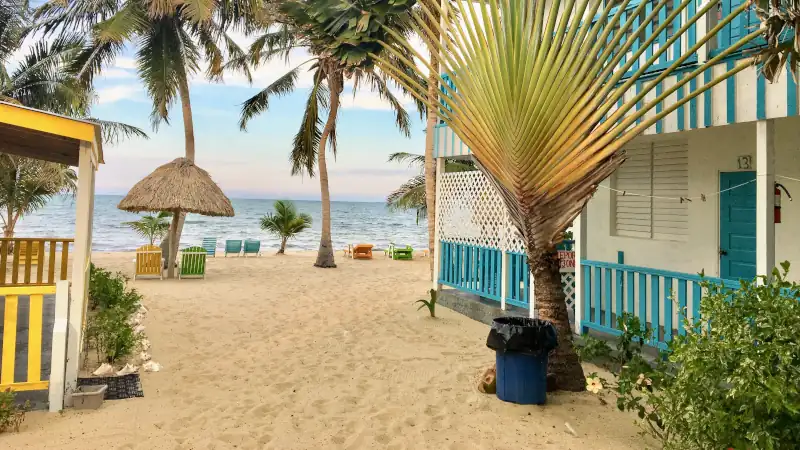 Beautiful sandy beach with a beach house surrounded by sand and flowers in the tropical town of Placencia, Belize