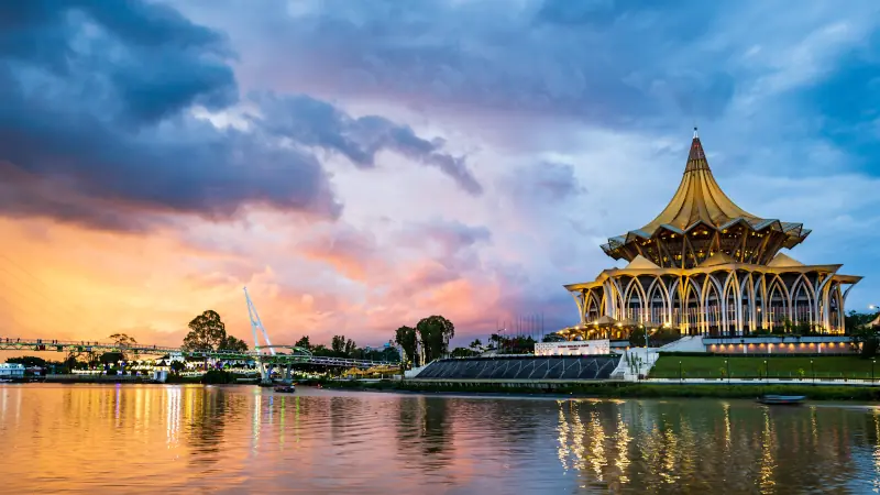 Kuching city waterfront sunset with river and landmarks in Sarawak, Malaysia.