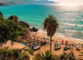 Nerja, Málaga. Sunny view of the Mediterranean Sea from Costa del Sol. With clean water, people at the sand and giant palm trees.
