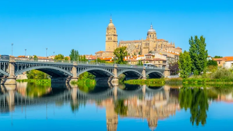 Cathedral at Salamanca reflected viewed behind bridge of enrique esteven on river Tormes, Spain. live in the mediterranean places in the mediterranean