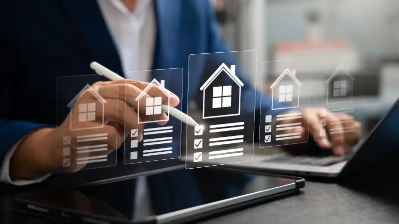 Businessman reviews real estate documents on laptop