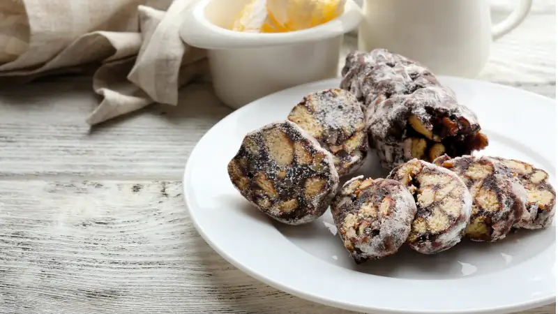 Chocolate salami in a plate over wooden background