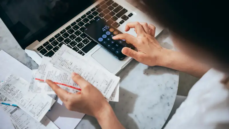 Overhead view of young Asian woman managing personal banking and finance at home