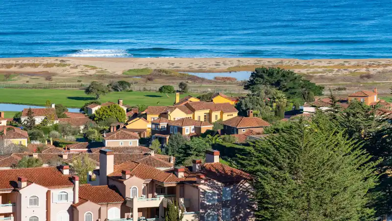The tranquil beauty of Quintay's coastline in Chile, with residential buildings blending into the natural beach and ocean landscape.