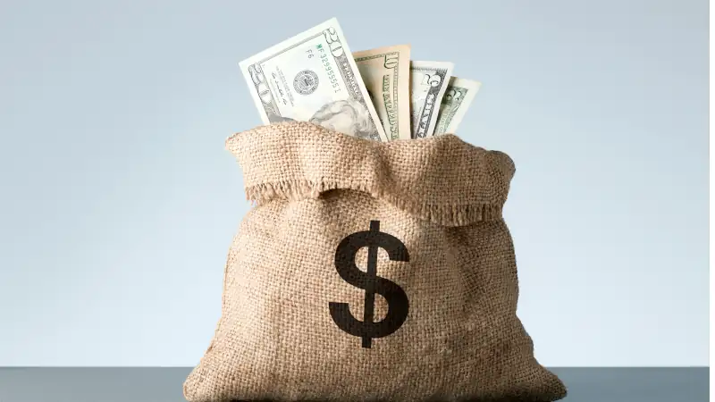 Burlap with dollar banknotes on gray background. Bribe or bonus concept