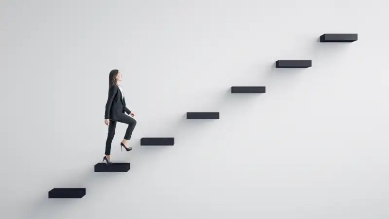 Woman in business attire climbing floating stairs