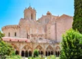 Exterior view of Tarragona Cathedral in Spain, with Gothic architecture and a garden courtyard in the foreground.