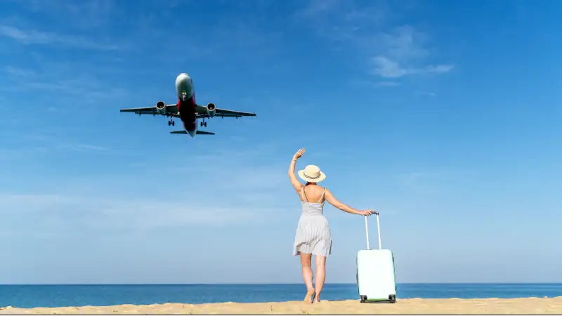 A woman meets a plane on the beach by the sea