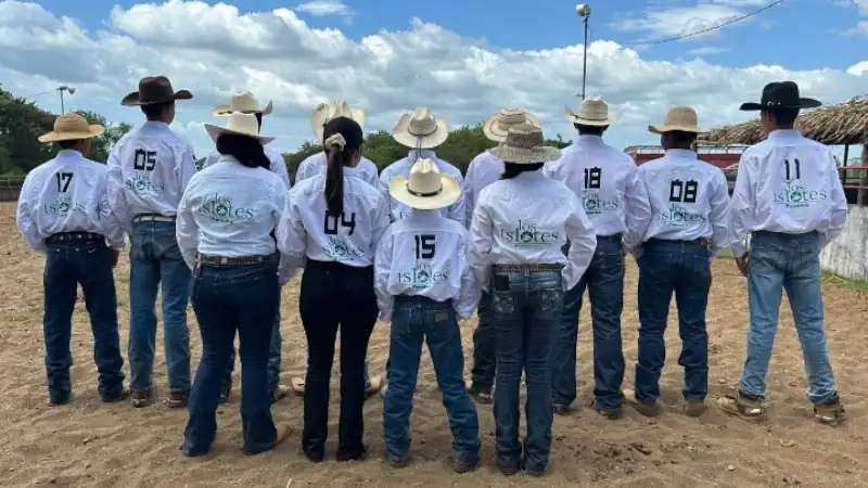 Veraguas junior rodeo team standing in a row with backs turned, wearing numbered shirts and cowboy hats.