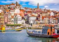 Colorful buildings along the Douro River with traditional boats in Porto, Portugal.