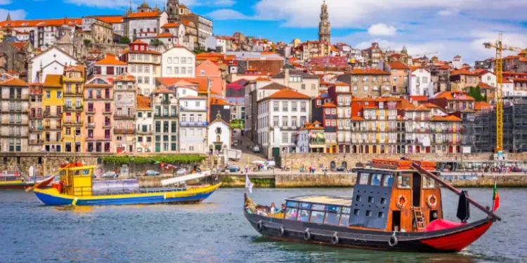 Colorful buildings along the Douro River with traditional boats in Porto, Portugal.