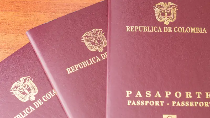 Close up of three Colombian passports fanned out on a wooden table