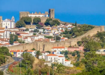 This is the medieval town of Óbidos, Portugal, known for its castle, stone walls, and whitewashed houses with red roofs. It’s a historic hilltop village surrounded by scenic countryside.