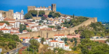 This is the medieval town of Óbidos, Portugal, known for its castle, stone walls, and whitewashed houses with red roofs. It’s a historic hilltop village surrounded by scenic countryside.