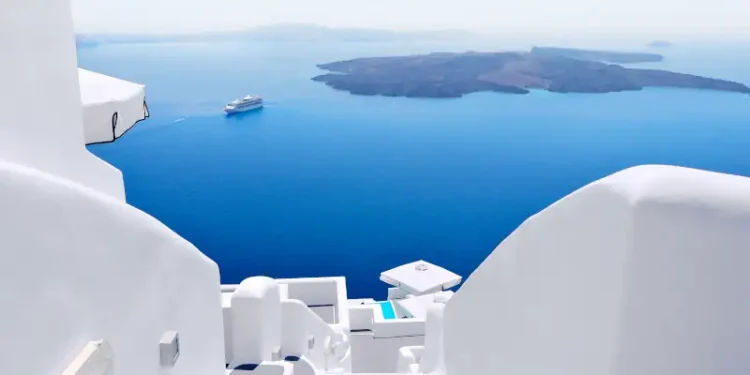 White wash staircases on Santorini Island, Greece. The view toward Caldera sea with cruise ship awaiting.