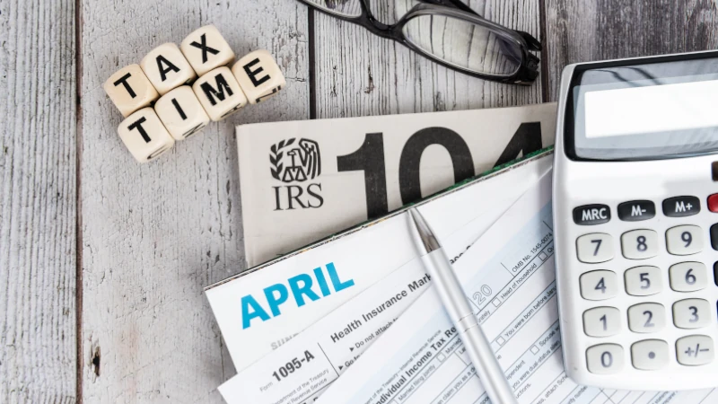 Tax forms, calculator, and glasses on a desk representing the process of paying taxes in Panama.