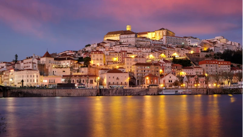 Coimbra city in Portugal. Night panorama with illumination and the Mondega River.