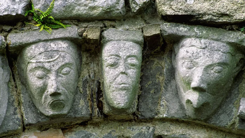 Carved stone human and animal heads on Romanesque door arch of ancient monastic church at Dysert O'Dea, County Clare, Ireland.