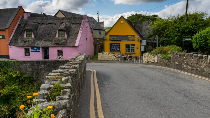 bridge leads to colorful houses in the old village center of Doolin
