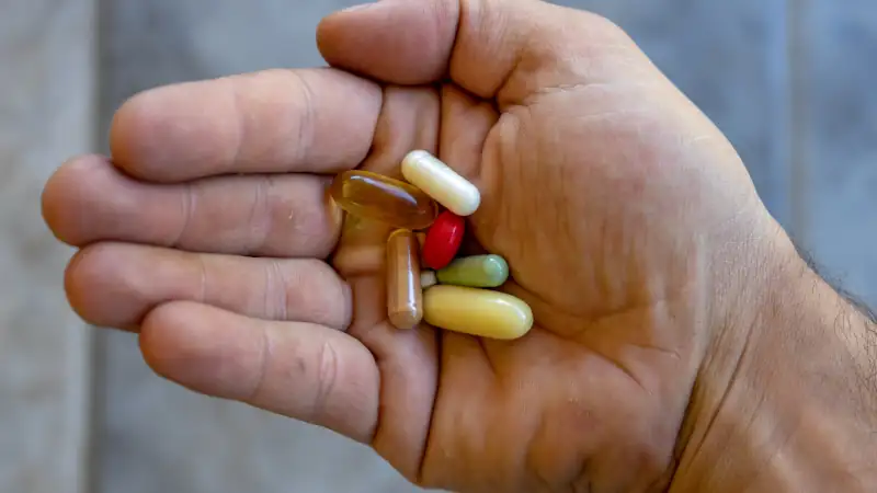 A man's hand full of pills (medicines)