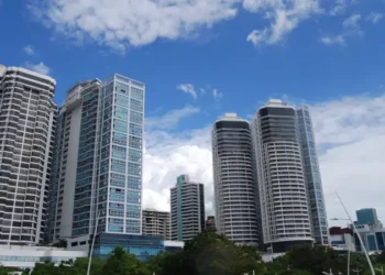 Modern high-rise buildings along Avenida Balboa in Panama City under a bright blue sky.