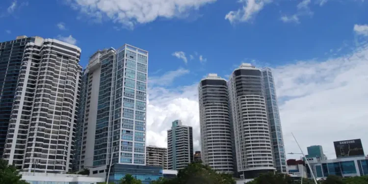Modern high-rise buildings along Avenida Balboa in Panama City under a bright blue sky.
