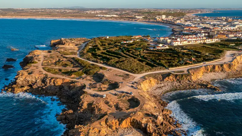 Peniche peninsula with high cliffs and ocean tide at sunset, Portugal