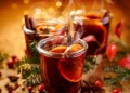 Christmas mulled red wine with aromatic spices and citrus fruits on a wooden rustic table