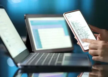 Woman hand using multiple devices at home in the night