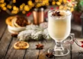 Traditional winter eggnog in a glass mug with milk, rum and cinnamon, christmas decorations