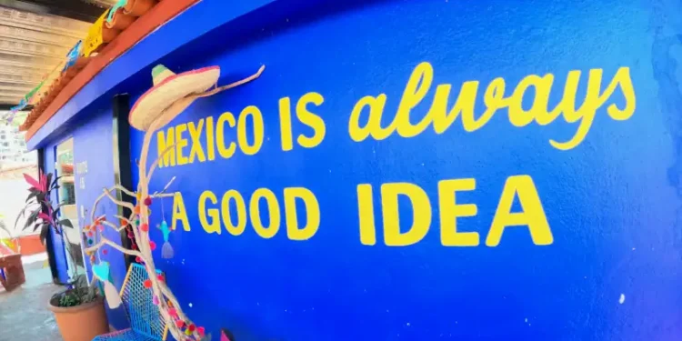 A brightly painted blue wall features the phrase “Mexico is always a good idea” in yellow letters