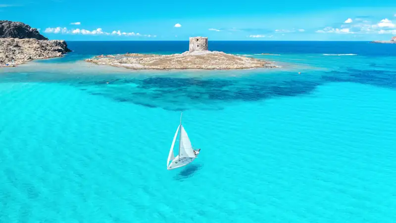 Beautiful seascape with white sailing yacht in summer on a sunny day aerial view.