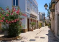 Charming Street Scene in Olhão, Portugal – Blooming Flowers, Cobblestones, and Blue Facades