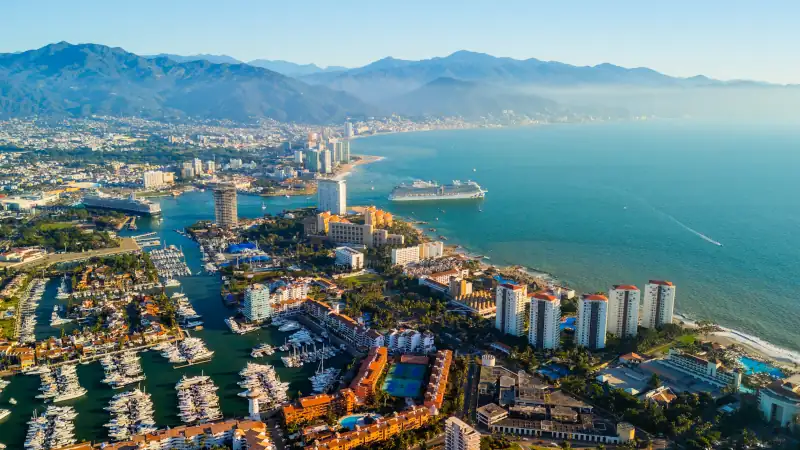 Puerto Vallarta skyline showing marina and cruise ships at sunset.