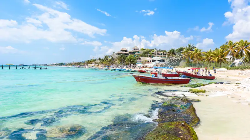 Playa del Carmen - relaxing on chair at paradise beach and city at caribbean coast of Quintana Roo, Mexico