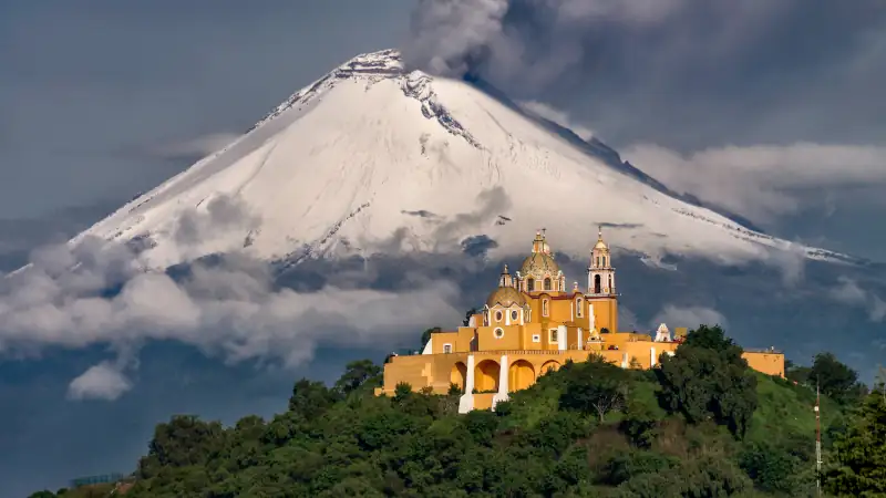 Morning view of church and a volcano behind with snow