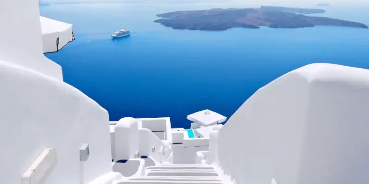 White wash staircases on Santorini Island, Greece. The view toward Caldera sea with cruise ship awaiting.