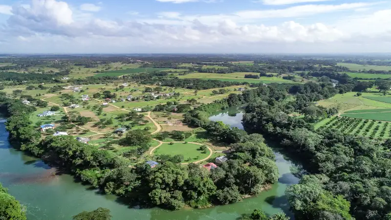 aerial view of Belize river valley community with homesites, greenery, and riverfront land