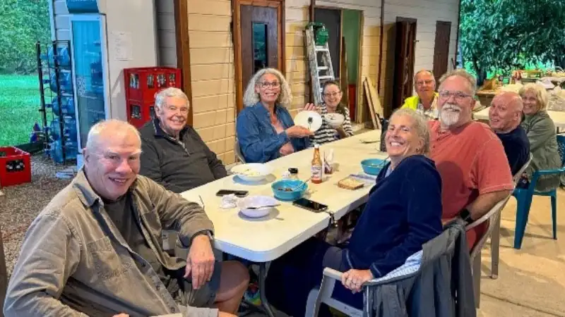 Group of residents enjoying a casual dinner together at a table in Carmelita Gardens