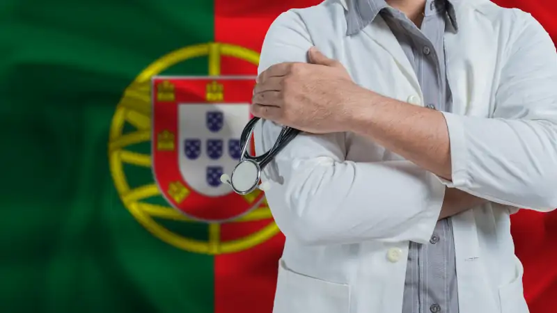 Doctor with stethoscope on arm with Portugal flag behind.